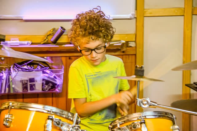 ילד מתופף בשיעור תופים